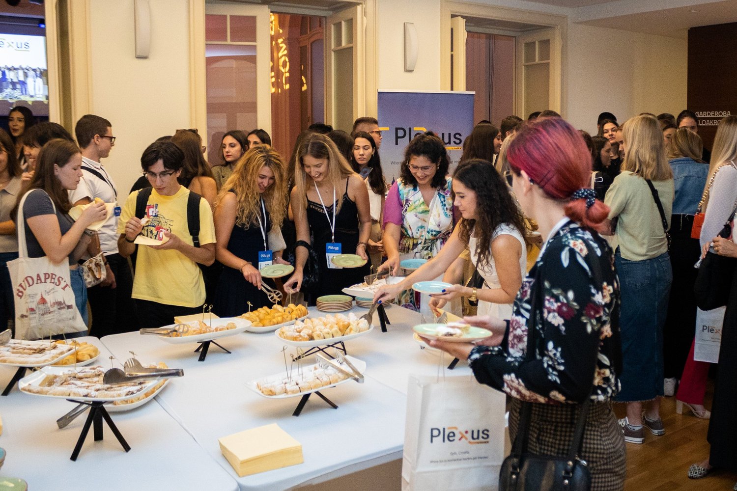 Attendees gathered around the morning pastry buffet at Plexus