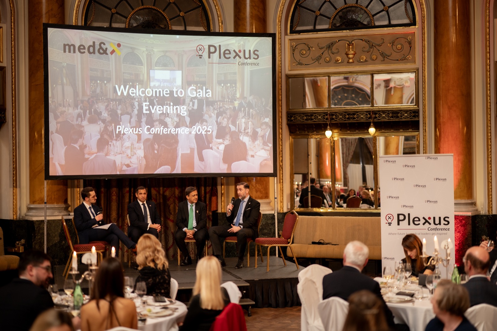 Speakers on stage in front of partners and guests at the Gala Evening